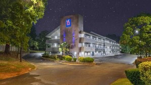 A hotel with a prominent '6' logo, a parking lot, and well-maintained landscaping. - Clean ADA King Bed|Nsmk (Charlotte NC)