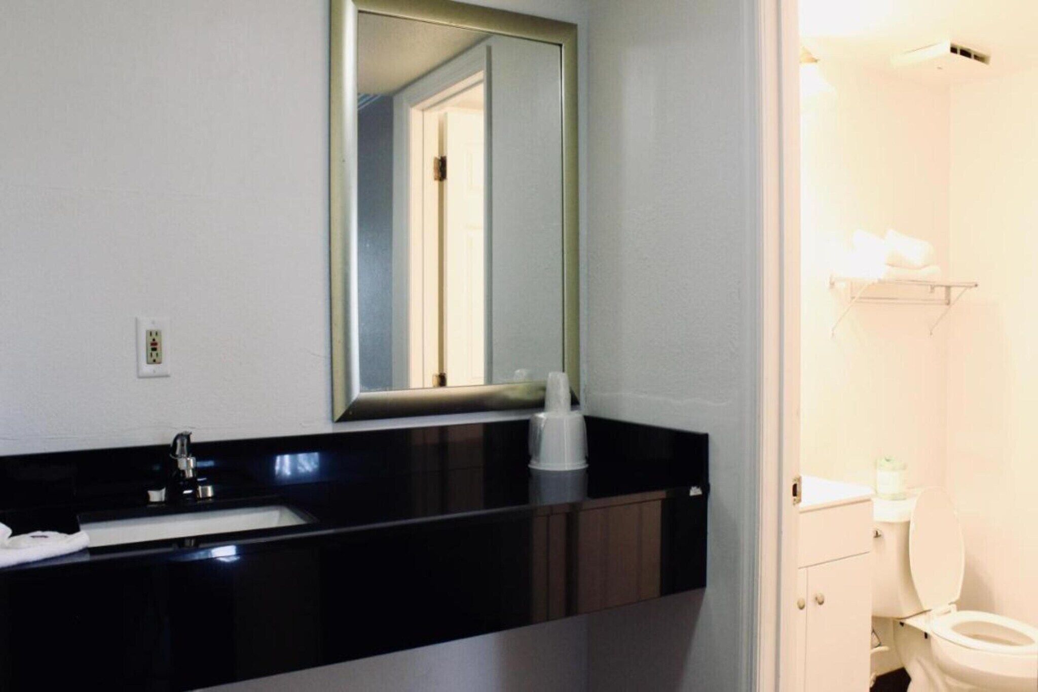 A bathroom with a sink, mirror, and toilet.