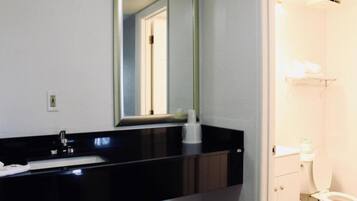 A bathroom with a sink, mirror, and toilet.
