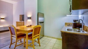 A compact kitchen with a dining table and chairs, a built-in oven, and a sink. - 2 Full Beds | Non-Smoking, Kitchen (Bakersfield)