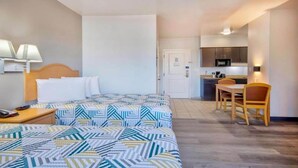 A hotel room with a bed, bedside table, lamp, and a kitchenette area with a microwave and sink. - 2 Full Beds | Non-Smoking, Kitchen (Bakersfield)