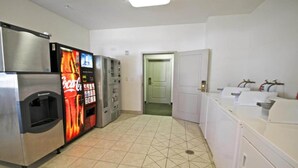 A hotel bathroom with a Coca-Cola vending machine, a Scottsman refrigerator, and a sink area. - 2 Full Beds | Non-Smoking, Kitchen (Bakersfield)