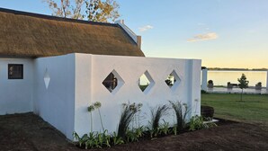 A white building with a thatched roof, a small window, and a geometric design on the facade.