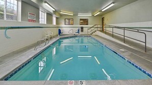 An indoor swimming pool with a 5 ft depth marker, a warning sign, and a staircase leading to an upper level. - 1 Queen Bed | Suite, Non-Smoking (MERIDIAN)