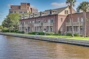 Un hotel frente al agua con edificios de ladrillo, balcones y un canal.