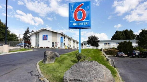 Schild eines Motels mit der Nummer 6 und einem Pfeil, der nach links zeigt und den Eingang weist.