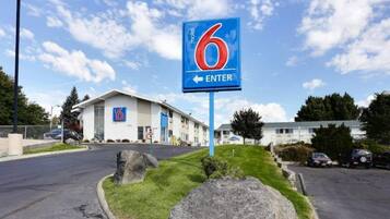 A motel sign with the number 6 and an arrow pointing left, indicating the direction to enter.