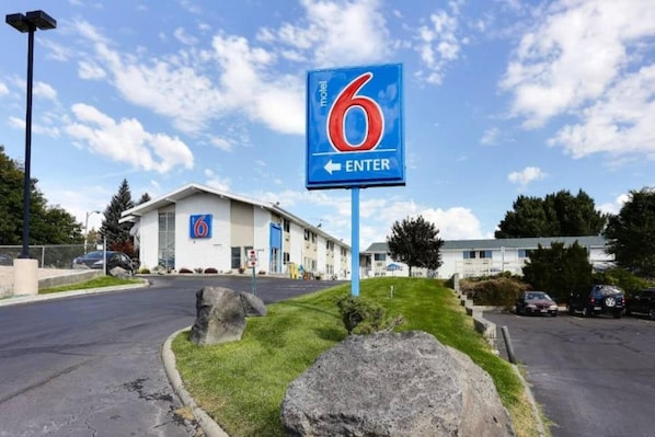 A motel sign with the number 6 and an arrow pointing left, indicating the direction to enter. - 1 Queen Bed | Non-Smoking (Idaho Falls)