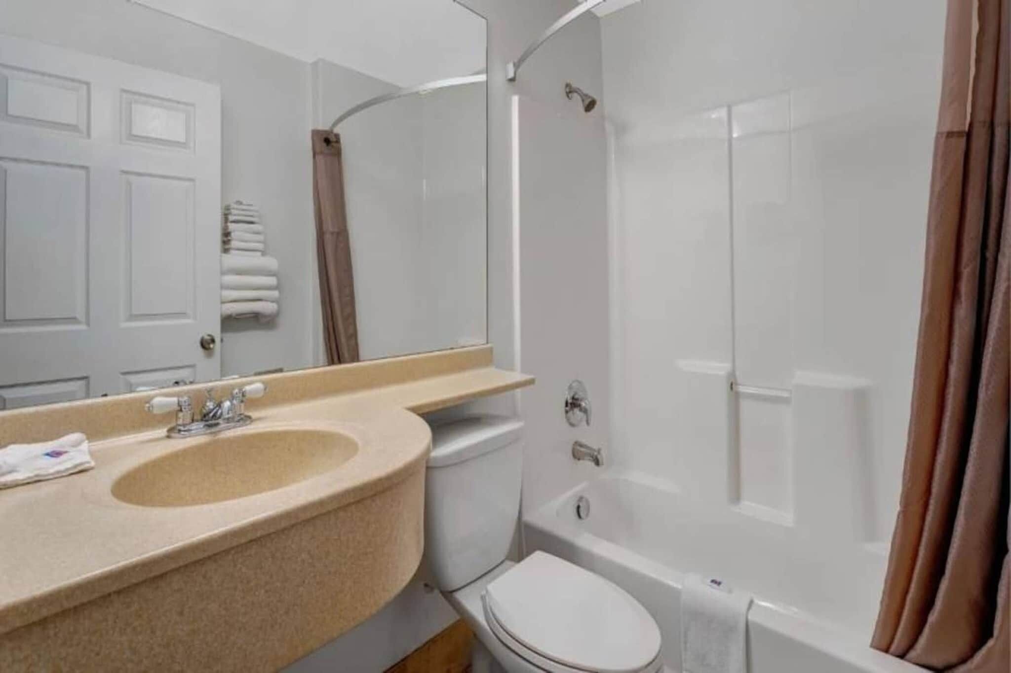 A bathroom with a sink, toilet, and shower.