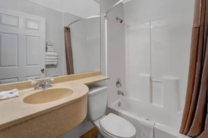 A bathroom with a sink, toilet, and shower.