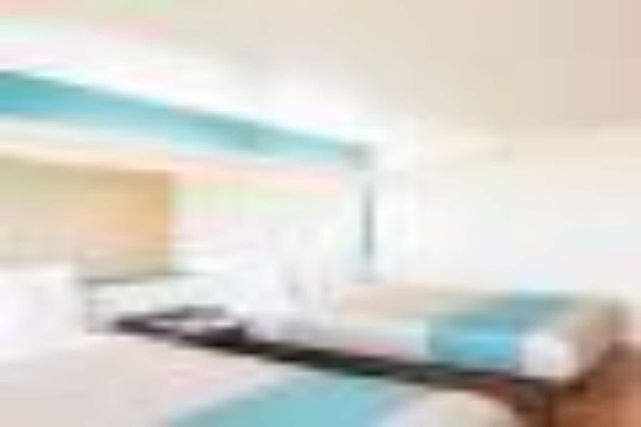 A hotel room with a bed, a desk, and a window.