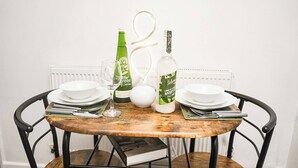 A dining table set with plates, cutlery, a glass, a bottle, and a pitcher. - Sleeps 4, Great for Groups, Free Parking Kent (Medway)