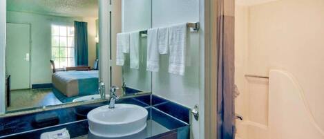 A bathroom with a sink, mirror, and toilet.