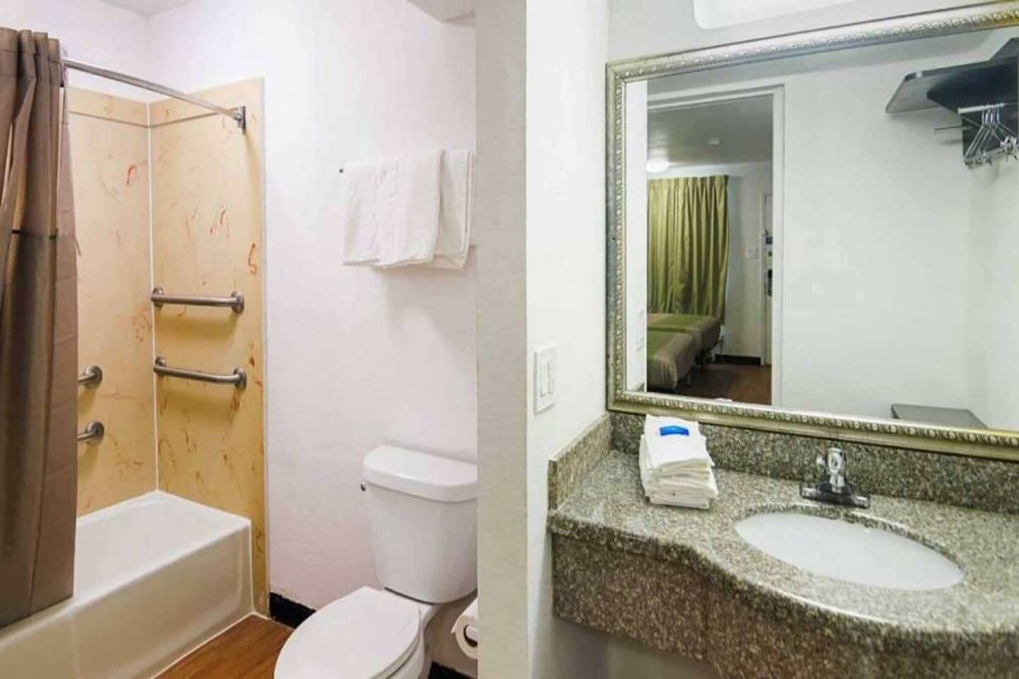 A bathroom with a shower, toilet, and sink.