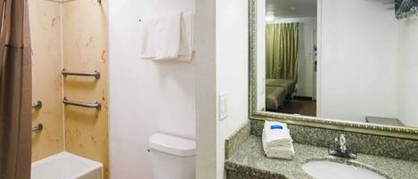 A bathroom with a shower, toilet, and sink.
