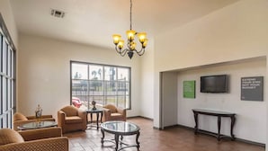 A lobby with a chandelier, seating area, a TV, and a wall with motivational quotes. - 1 King Bed | Smoking, Kitchen (Tyler TX)