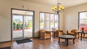 A lobby with a glass door entrance, a chandelier, and several chairs and tables. - 1 King Bed | Smoking, Kitchen (Tyler TX)