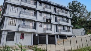 A multi-story building with balconies, a gated entrance, and a clear sky. - Collection O Lapalang Shillong (Shillong)