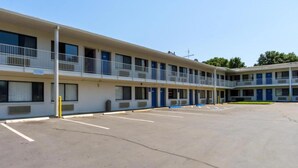 A motel with a central courtyard, multiple balconies, and a parking lot.