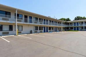 A motel with a central courtyard, multiple balconies, and a parking lot.