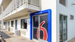 A building with a blue entrance marked 'welcome' and a large number '6' on the glass door.