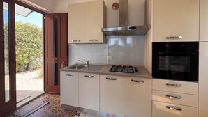 Eine moderne Küche mit Gasherd, Backofen und integrierter Dunstabzugshaube.