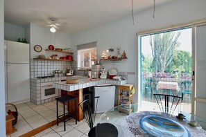 A kitchen with a gas stove, a refrigerator, a sink, and a window overlooking a garden. - Villa in Marina Di Modica with 3 bedrooms sleeps 7 (Marina Di Modica)