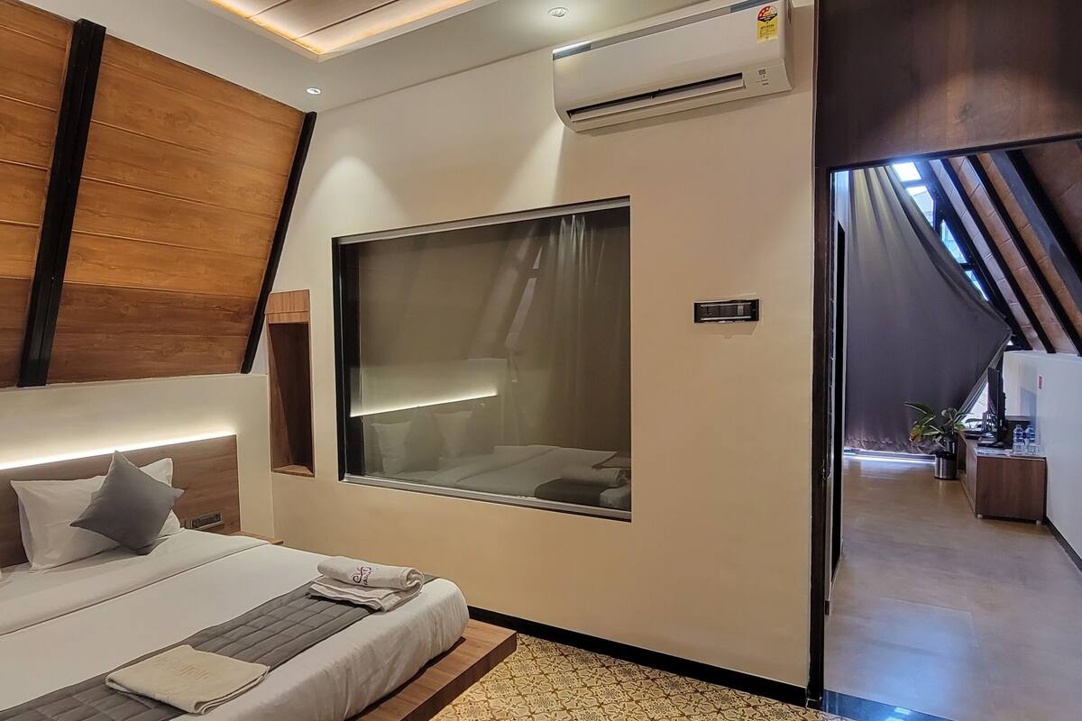 Un dormitorio moderno con cama, mesita de noche y un amplio ventanal.