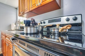 A kitchen with wooden cabinets, a stainless steel stove, and a pot on the counter. - Walkable Base Near Dtwn, Penn Station & MetLife (Newark)