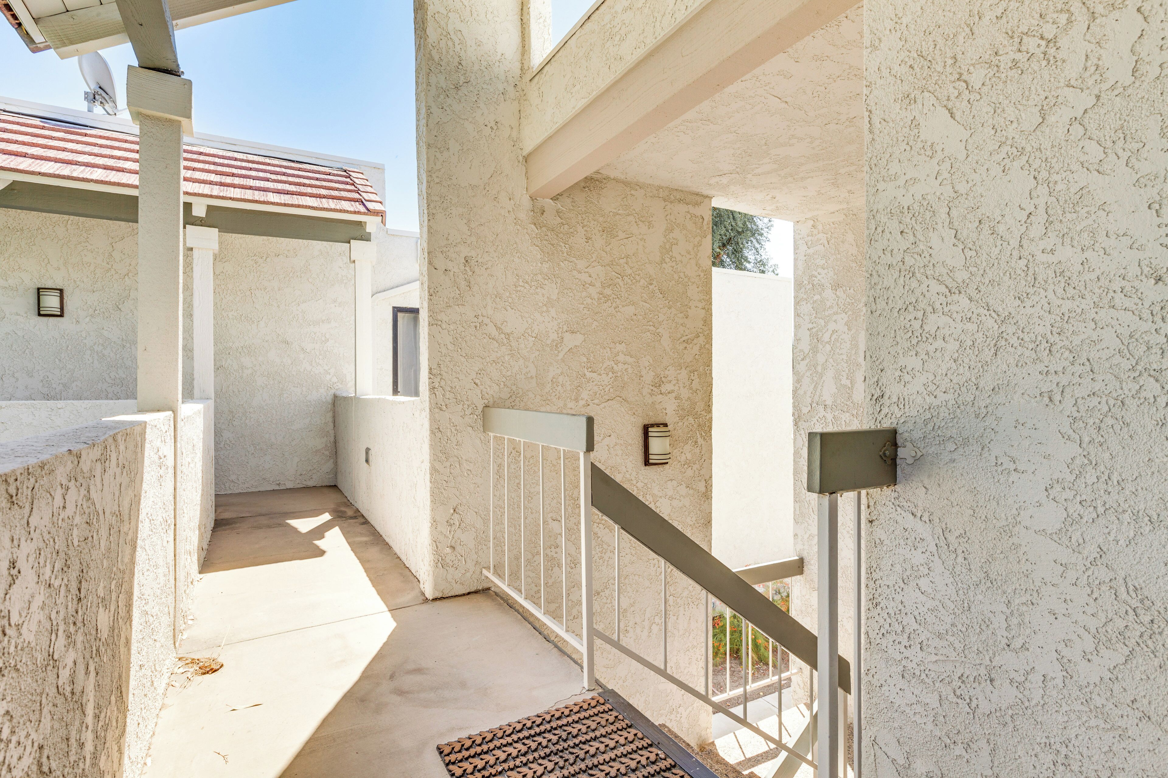 A modern building with a concrete exterior, a metal staircase, and a small balcony area.