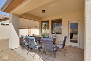 An outdoor patio with a table and chairs, a potted plant, and a sliding glass door. - Golf, Gamble & Get Away! Mesquite Desert Retreat (Mesquite)