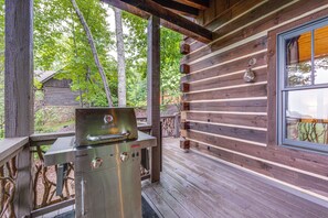 A wooden cabin with a metal grill on the porch, surrounded by trees. - Franklin Cabin w/ Hot Tub, Theater & Fire Pit! (Franklin)