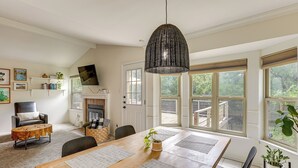 A dining area with a wooden table, black chairs, and a hanging light fixture. - Pet-Friendly Yard w/ Hot Tub! Peaceful Austin Home (Austin)