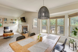 A dining area with a wooden table, black chairs, and a hanging light fixture. - Pet-Friendly Yard w/ Hot Tub! Peaceful Austin Home (Austin)