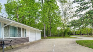 Il s'agit d'une propriété résidentielle dotée d'une allée en béton, d'un panier de basketball et d'une maison avec un porche abrité.