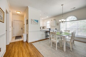 A dining area with a table, chairs, and a chandelier. - Myrtle Beach Golf Getaway! Snowbirds Welcome (Myrtle Beach)