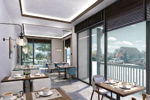 Un comedor moderno con mesas y sillas, ventanas amplias y vistas al exterior.