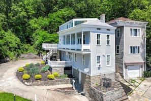 Ein zweistöckiges Haus mit Balkon, Stein Fundament und angelegtem Garten.