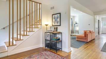 A staircase with wooden steps and a black metal console table with storage.