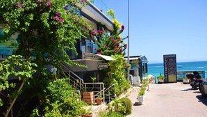 A hotel with a reception area, outdoor seating, and a view of the sea. - Sultans And Kings Hotel (Didim)