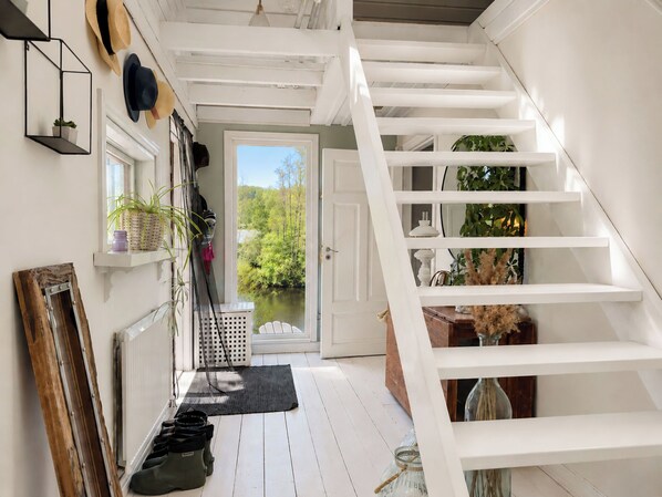 A white staircase leading to a door with a view of greenery outside. - Knäredsdrömmen by Interhome (Halmstad)