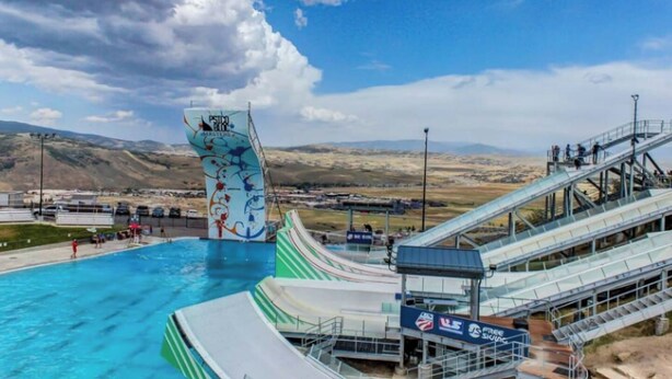 Ein Wasserpark mit einem großen Schwimmbecken, einem Wellenbecken und einer Skilift.