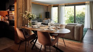Uma sala de jantar com mesa de madeira, cadeiras e um sofá.