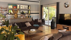 Un salon moderne avec un canapé, une table basse et un téléviseur.