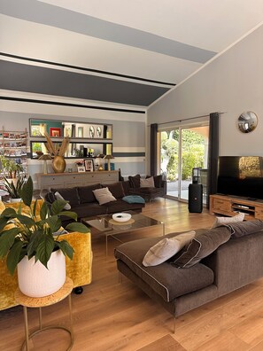 Ein modernes Wohnzimmer mit einer Couch, einem Couchtisch und einem Fernseher.