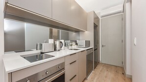 Ett modernt kök med vitvaror i rostfritt stål, en inbyggd ugn och en mikrovågsugn.