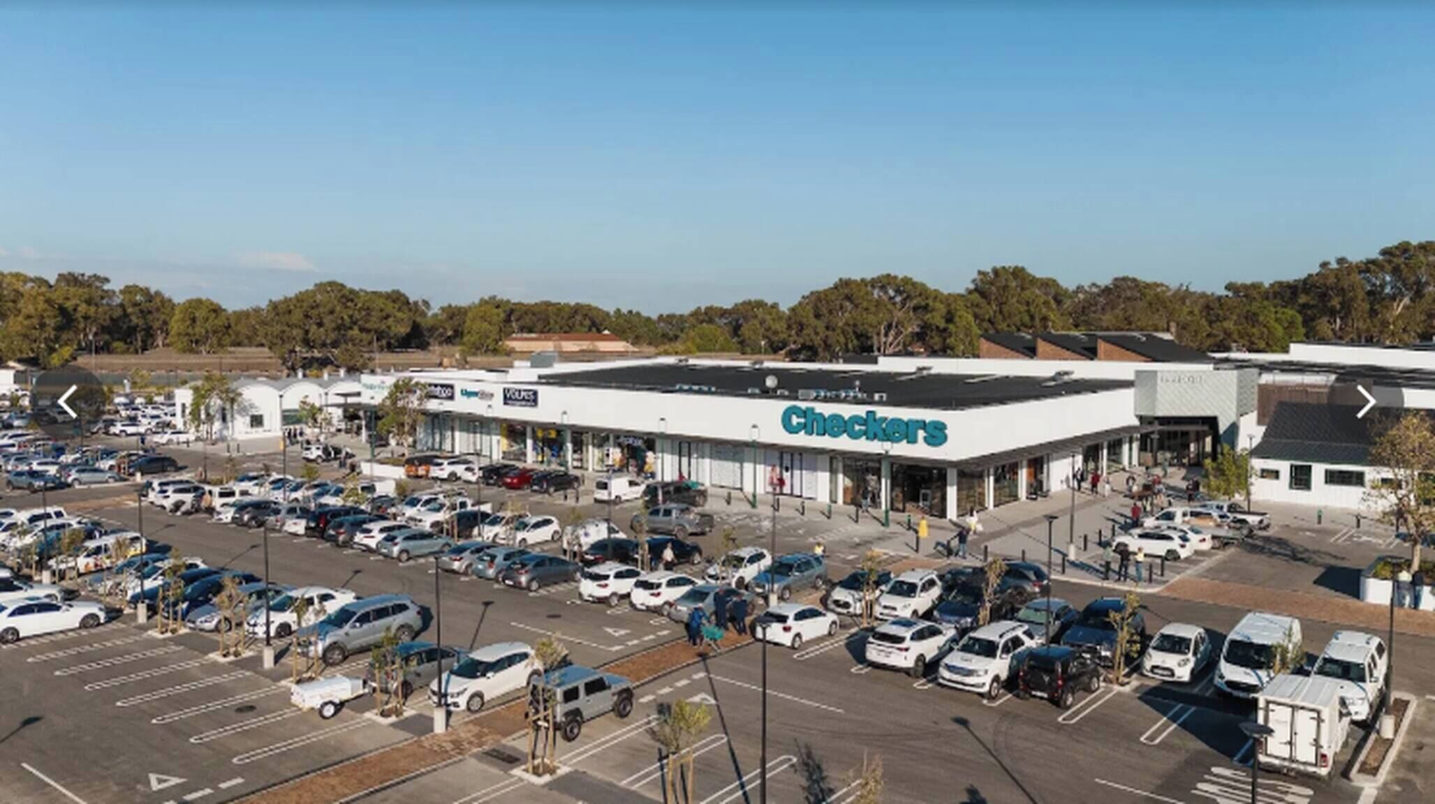 Un ampio parcheggio con un negozio Checkers e un edificio a tetto piatto.
