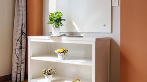 A bathroom vanity with a mirror, shelves, and a potted plant. - Summer Inn Sanya (Sanya)