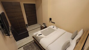 Une chambre d’hôtel équipée d’un lit, d’un bureau, d’un téléphone et d’une armoire.