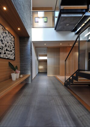 Ein modernes Interieur mit einer Treppe, einer Holzbank und einem an der Wand befestigten Kunstwerk.
